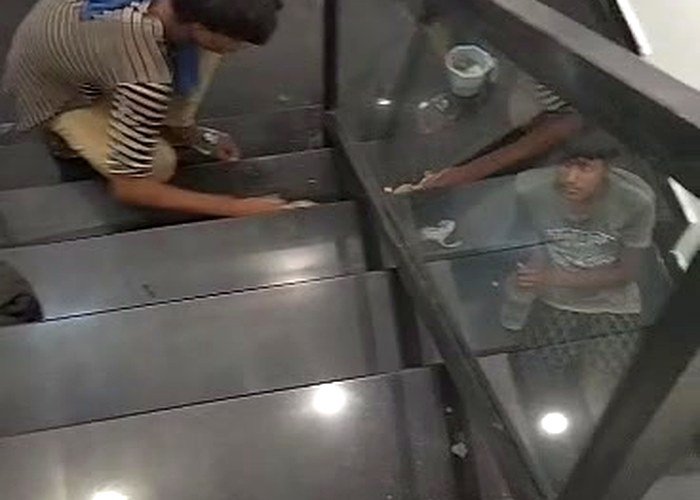 Makhdoom Services team cleaning glass staircase railing in Lahore