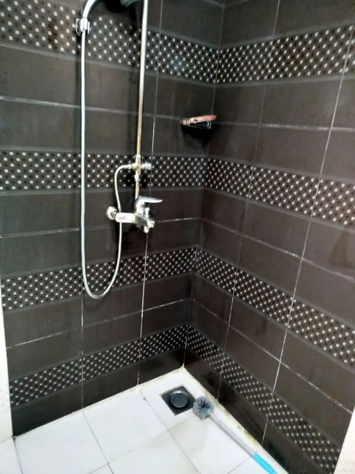 Same shower area after deep cleaning: limescale removed from wall tiles and fittings