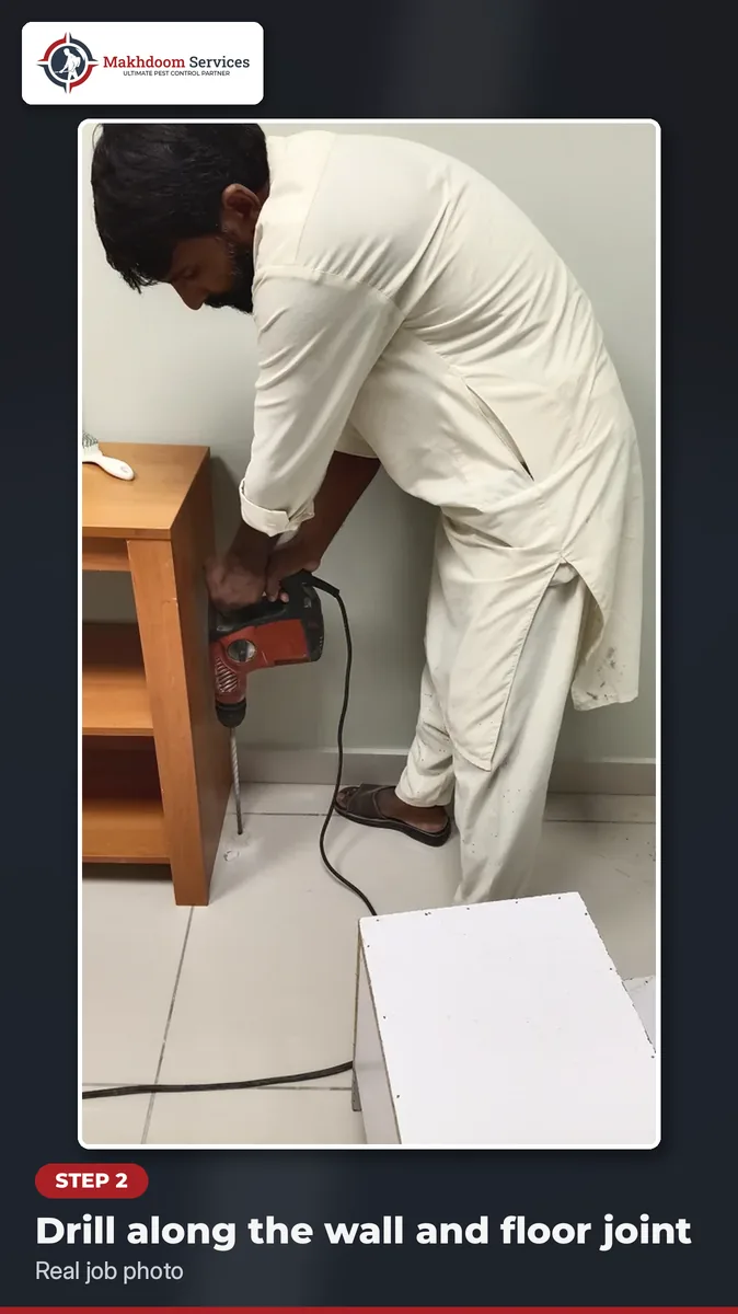 Step 2 of termite treatment at home: drilling holes along the wall and floor joint